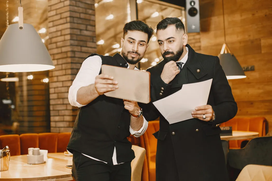 Restaurant managers reviewing delivery demand and branch performance on a tablet