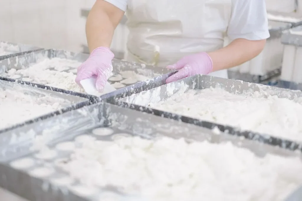 Commercial bakery team preparing trays of pastries for daily production
