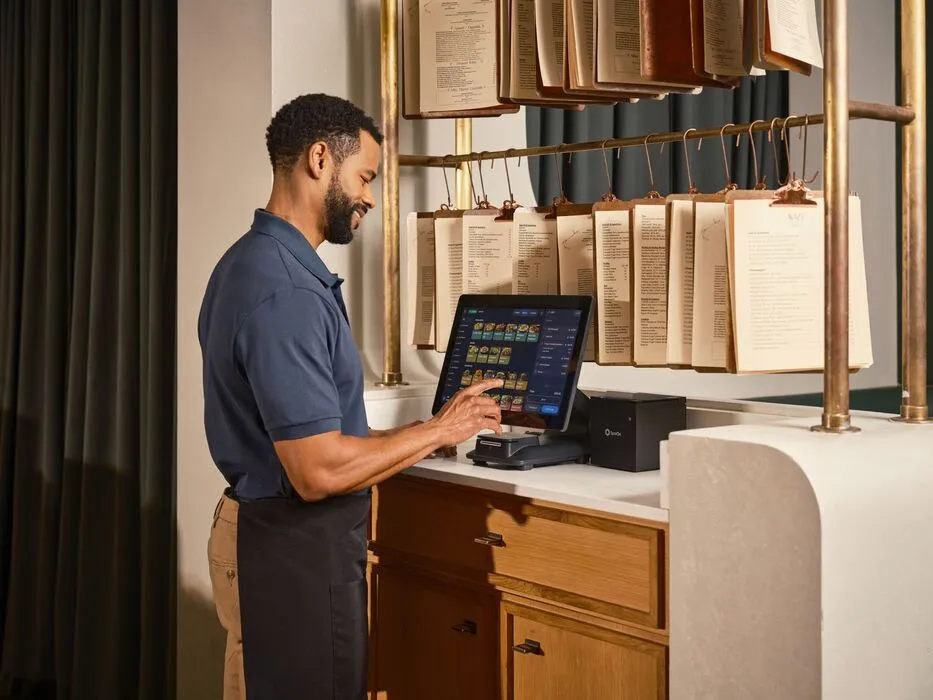 Restaurant manager reviewing point-of-sale activity at the counter