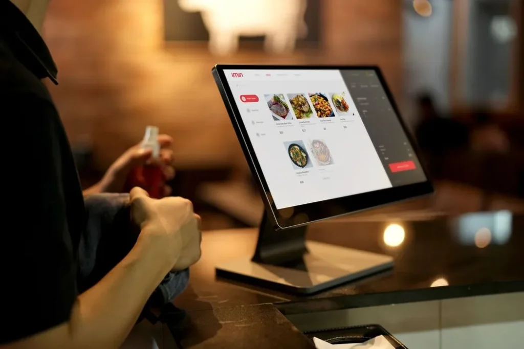 Restaurant manager reviewing a guest service issue with a tablet in a modern dining room